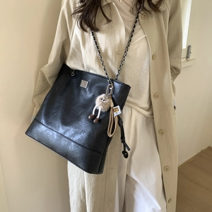 Détail du grand sac cabas noir vintage avec bandoulière chaîne et breloque en peluche