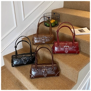 Detail of four retro underarm bags in glossy wrinkled leather with silver buckle accents