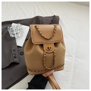 Detail of retro tan bucket backpack featuring metal chain trim and gold ring twist lock