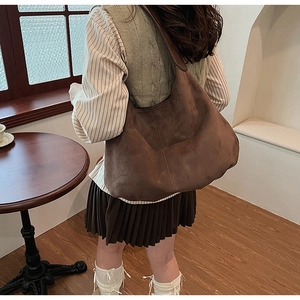 Brown suede tote bag side view showing textured finish and wide shoulder strap
