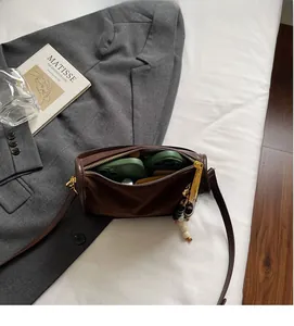 Brown leather handbag interior view showing space for phone with beaded charm detail