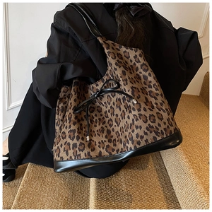 Detailed view of leopard print tote bag with black leather bow and suede texture