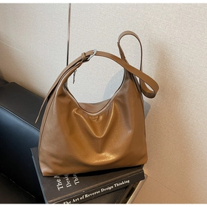 Macro shot of dark brown hobo bag with adjustable silver buckle and crinkled texture