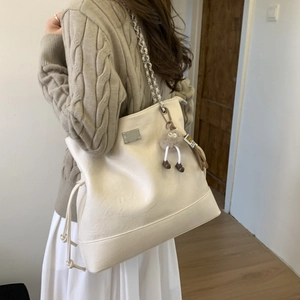 Détail du sac cabas blanc crème avec bandoulière en chaîne et pendentif peluche