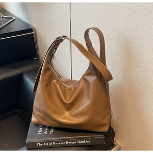 Close-up detail of vintage caramel tote bag with soft leather texture and silver zipper