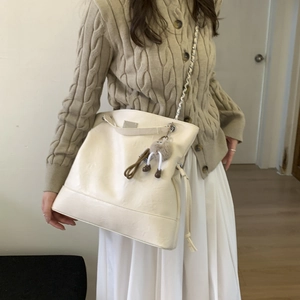Détail du sac cabas blanc cassé avec fermeture à cordon et garnitures métalliques sur mannequin