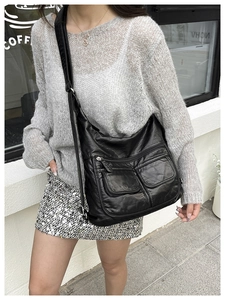 Close-up of black litchi texture shoulder bag with multiple functional pockets on front