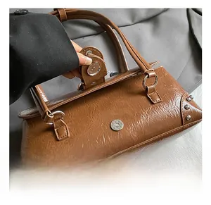 Close-up of vintage brown wrinkled leather bag with silver rivets and magnetic closure