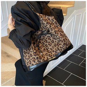 Close-up of leopard print suede tote bag with leather trim and bow detail