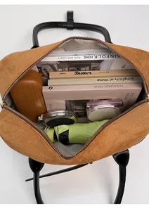 Detail view of large brown suede tote bag showing spacious interior with daily essentials