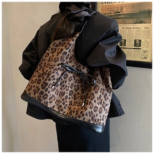 Close-up of leopard print tote bag with black bow detail and reinforced leather bottom
