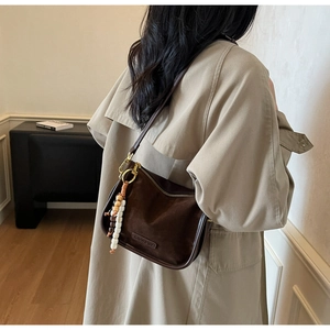 Vue détaillée d'un sac à bandoulière vintage en cuir mat marron avec pompon en perles colorées