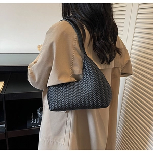 Dettaglio della borsa hobo intrecciata nera con tracolla in pelle e trama a motivo a V