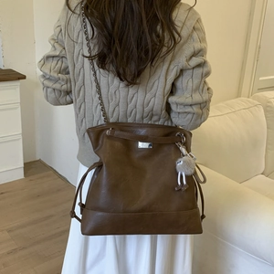 Détail du grand sac cabas marron foncé avec chaîne en métal et petit pendentif peluche