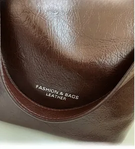 Gros plan détaillé du cuir marron foncé à grain litchi avec impression texte argent