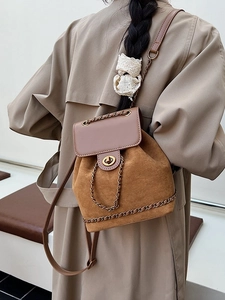 Brown suede bucket backpack for women featuring leather flap and gold chain details