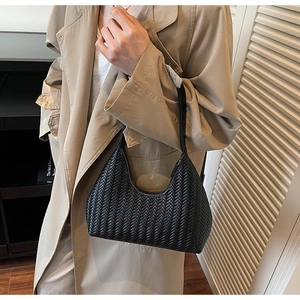 Dettaglio della borsa hobo intrecciata nera che mostra la trama fine sulla spalla