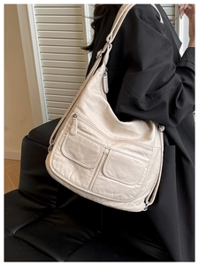 Detail of off-white faux leather tote with lychee texture and front zipper pockets
