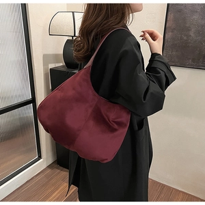 Fashionable burgundy large nylon hobo bag shown worn by model in a stylish interior setting