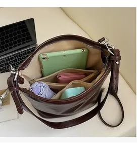 Intérieur spacieux du sac seau en cuir marron montrant sa grande capacité de rangement
