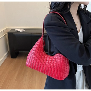 Dettaglio macro della trama intrecciata rossa e della forma a mezzaluna della borsa