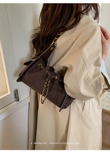 Détail d'un sac seau vintage marron foncé mat avec matelassage et chaîne dorée