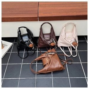 Détails de quatre sacs à dos rétro en noir, marron, crème et caramel avec porte-clés ours