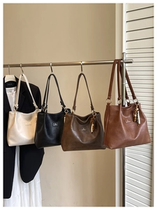 Detail of four retro shoulder bags in beige, black, and brown with beaded tassel charms