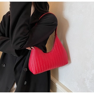 Dettaglio della borsa hobo rossa intrecciata con trama a V e tracolla coordinata