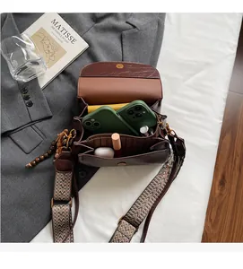 Detail view of multi-compartment interior storage in a brown vintage leather bag