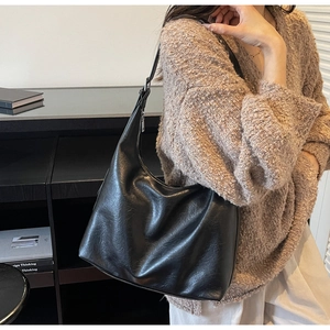 Close-up of black retro hobo bag with vintage leather texture and silver zipper detail