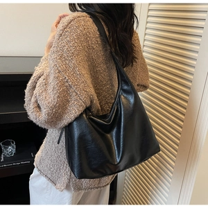 Detail of a black soft leather hobo bag showing spacious interior on female model
