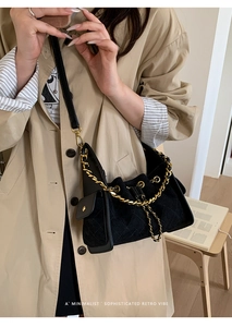 Détail du sac bandoulière matelassé noir avec chaîne dorée et petite poche latérale