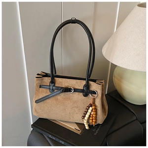 Detail of vintage matte brown tote bag with suede texture and wooden bead tassel accessory