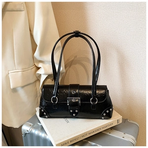 Close-up of vintage black leather pillow bag with silver rivet details and metallic buckle
