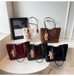 Detailed view of large leather tote bags in five colors with cute bear charms