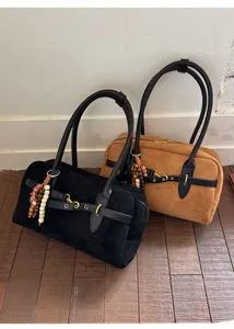 Detail of Boston bags with ethnic wooden bead charms in black and camel suede
