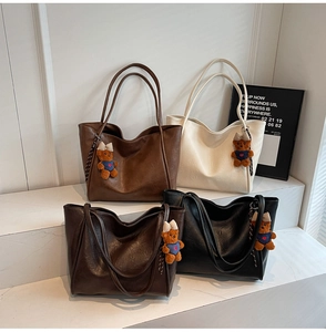 Detailed group shot of large minimalist tote bags in four colors with teddy bear charms