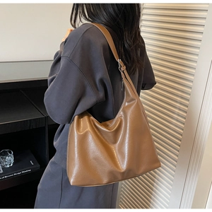 Brown large capacity leather hobo tote bag shown on model back for daily commute