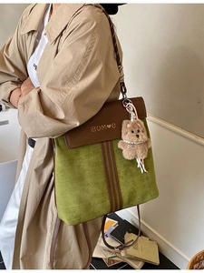Retro green and brown patchwork backpack with plush bear charm on khaki trench coat