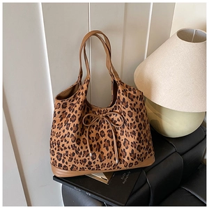 Close-up of leopard print tote bag featuring leather bow drawstring and suede texture