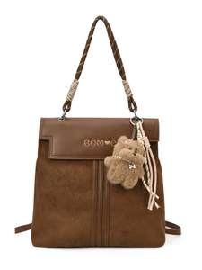 Brown leather backpack with woven handle, teddy bear charm, and colorful tassel details