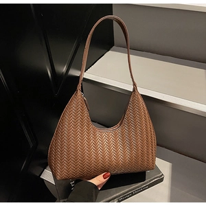 Dettaglio ravvicinato della trama intrecciata marrone su una borsa hobo minimalista