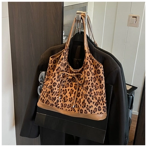 Detail of leopard print tote bag with brown faux leather trim and bow drawstring