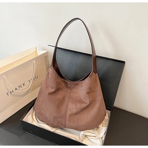 Close-up of a vintage brown hobo tote bag in a luxury gift box with satin lining