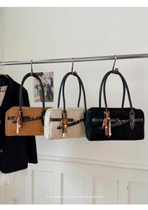 Detailed view of suede Boston bags in caramel, beige, and black with beaded charms