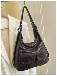 Close-up of brown faux leather bag with functional zipper pockets and wrinkled texture