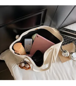 Interior view of white large capacity leather tote bag holding a tablet and daily essentials
