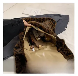 Detalle de la gran capacidad interior y el cierre magnético del bolso de peluche de leopardo