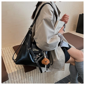 Détail du sac cabas en similicuir noir avec logo en métal et breloque ours en peluche
